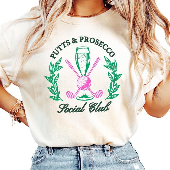 Close-up of Putts and Pros Social Club design on women's ivory golf shirt