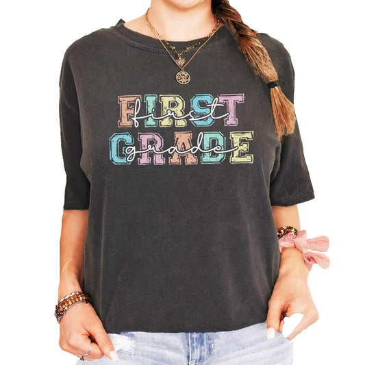 Front view of vibrant 1st Grade elementary school teacher shirt with colorful graphic print
