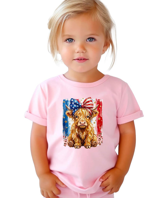 Front view of Olive Loves Apple Highland cow 4th of July shirt in pink with red white and blue bow and gold star accents