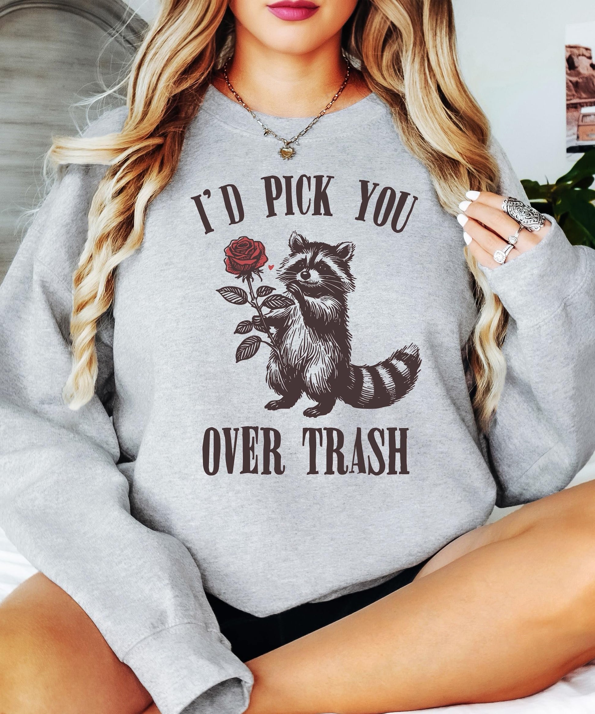 Family matching Valentine's Day sweatshirts with raccoon graphic displayed together in women's and kids sizes