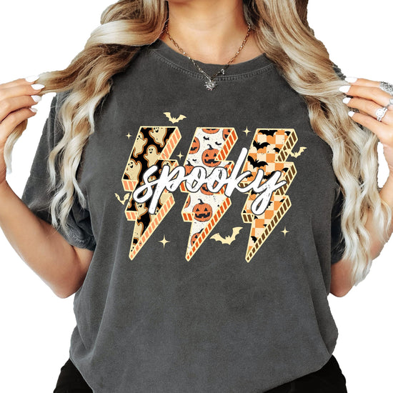 Side or lifestyle view of women's oversized Halloween graphic tee in dark brown with spooky lightning bolt print
