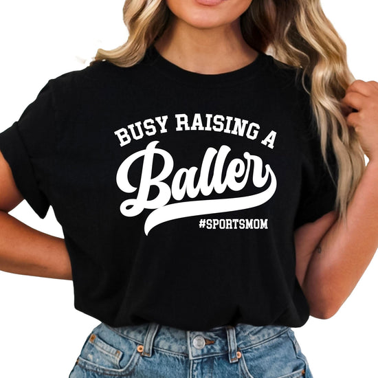 Sports mom graphic tee laid flat showing full front design on black shirt
