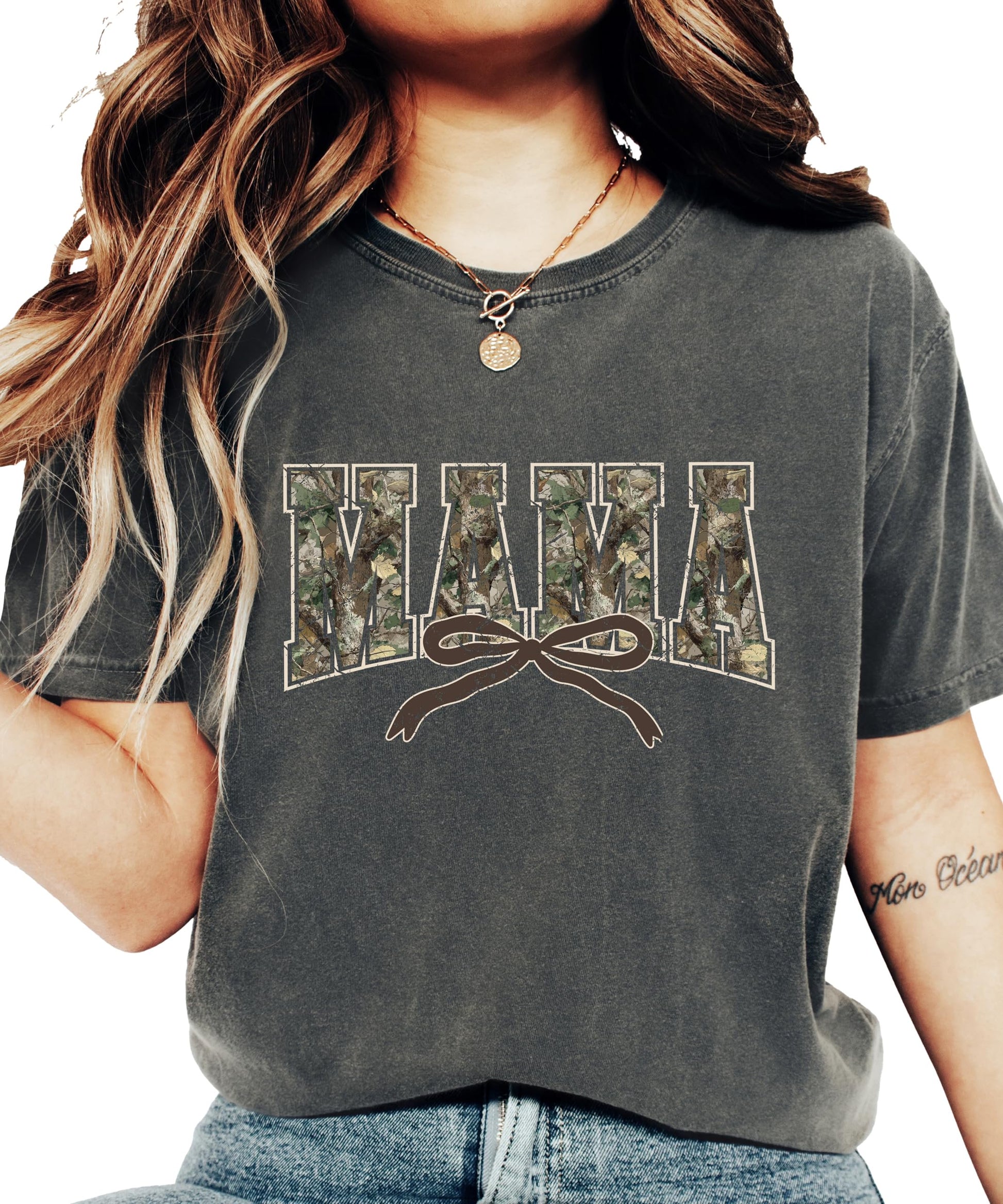 Detail shot of coquette bow and camo varsity letter print on seafoam women's graphic tee