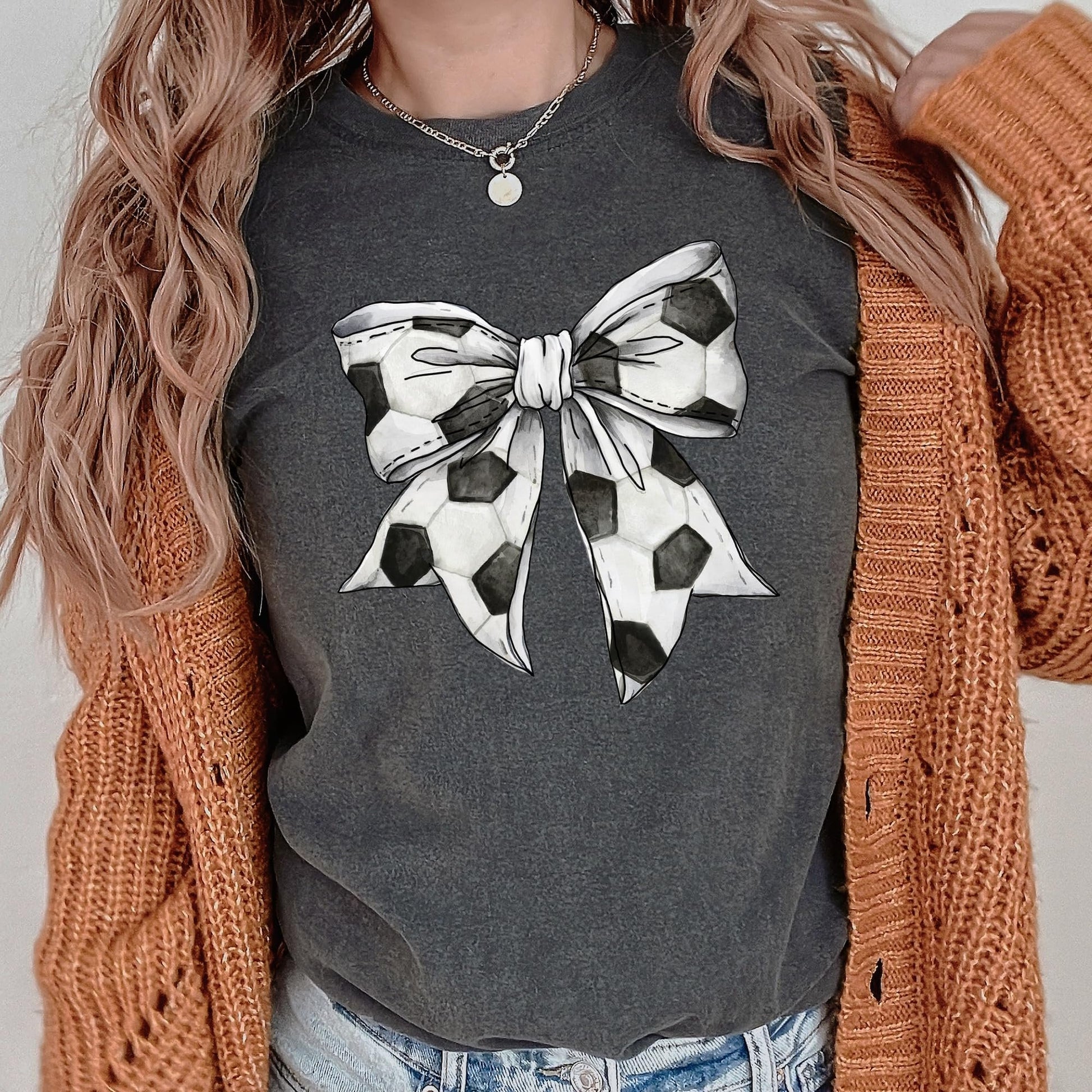 Model wearing oversized seafoam soccer coquette bow shirt, front view