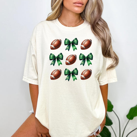 Close-up of football and green coquette bows print on ivory women's t-shirt