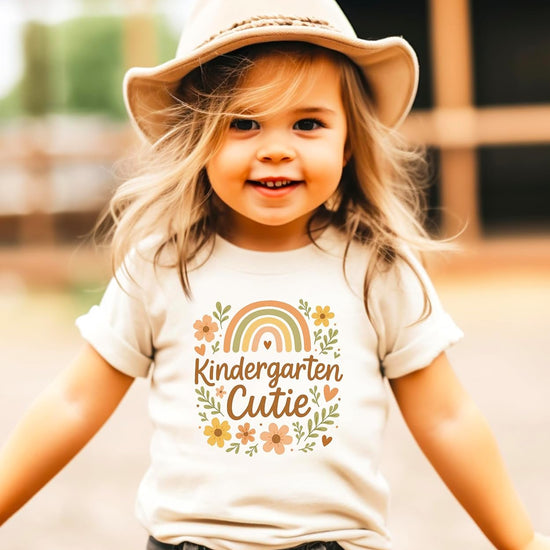 Young girl wearing Kindergarten Cutie boho floral graphic tee on first day of school