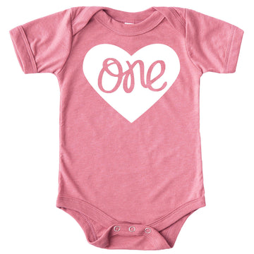 Close-up of One in a Heart first birthday bodysuit design on military green baby girl snap bodysuit