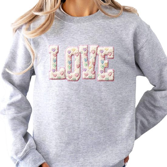 Side view of pink LOVE pullover sweatshirt showing relaxed casual fit