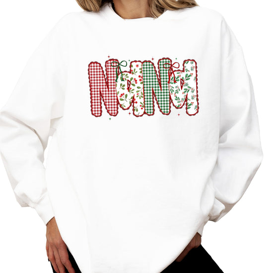 Close-up of festive red and green lace ink-print graphic on women's Christmas sweatshirt