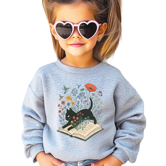 Close-up of black cat floral book lover sweatshirt print showing vibrant colors and detail on white fabric