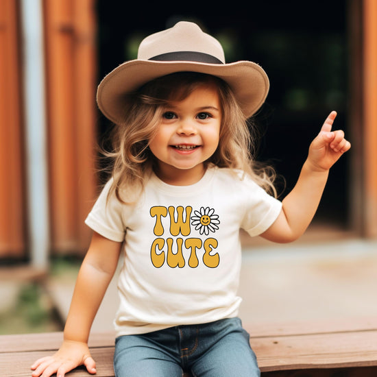 Flat lay of Two Cute daisy birthday shirt for toddlers in natural fabric