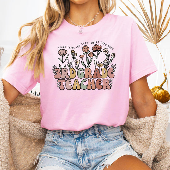 Flat lay of women's floral educator graphic tee in peach with teacher appreciation quote