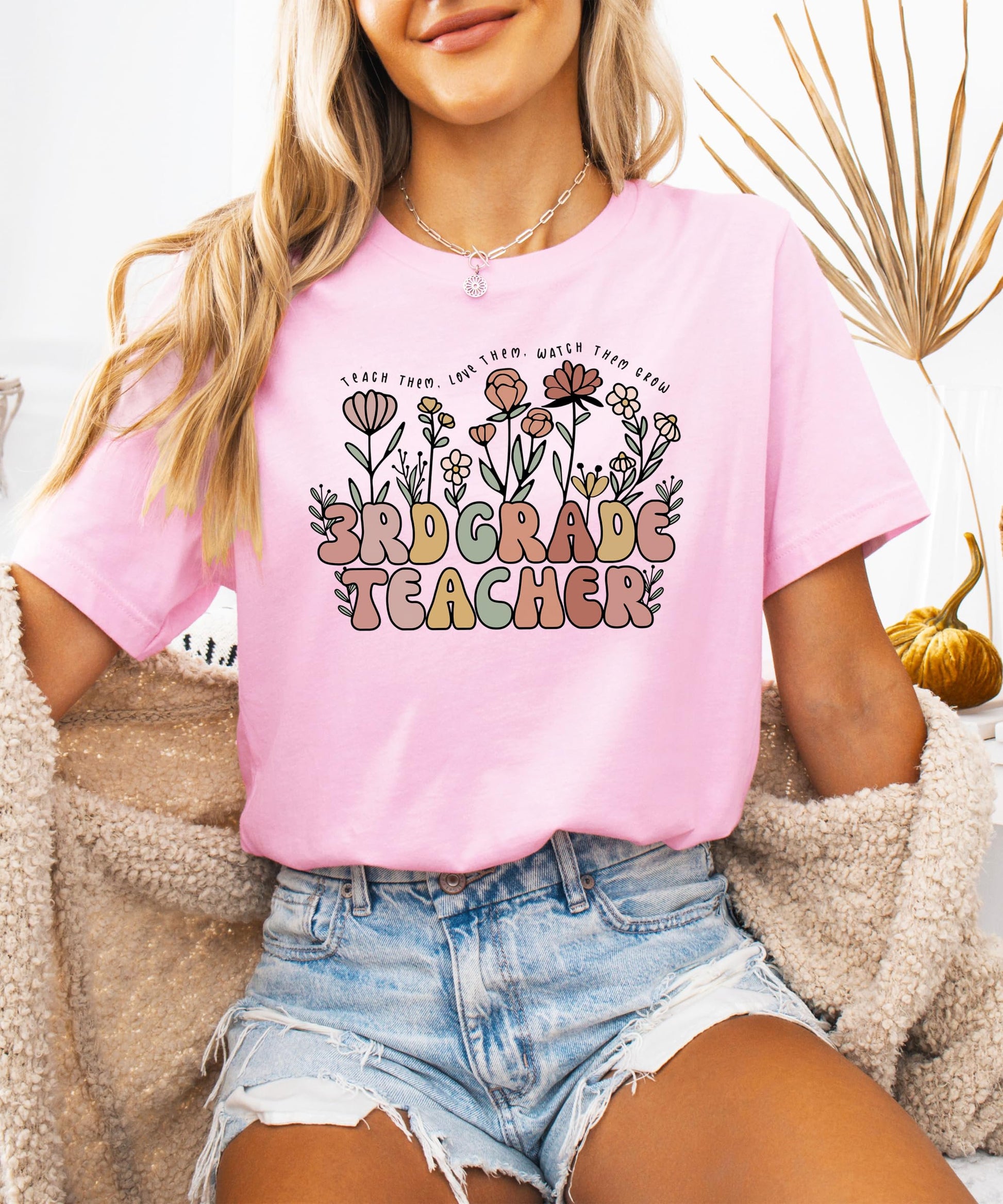Flat lay of women's floral educator graphic tee in peach with teacher appreciation quote