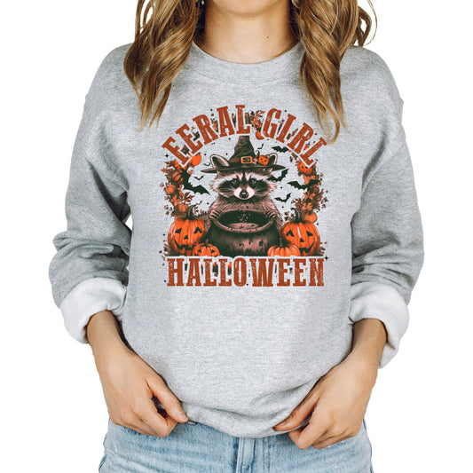 Women's gray crewneck sweatshirt with a witchy raccoon Halloween graphic on the front