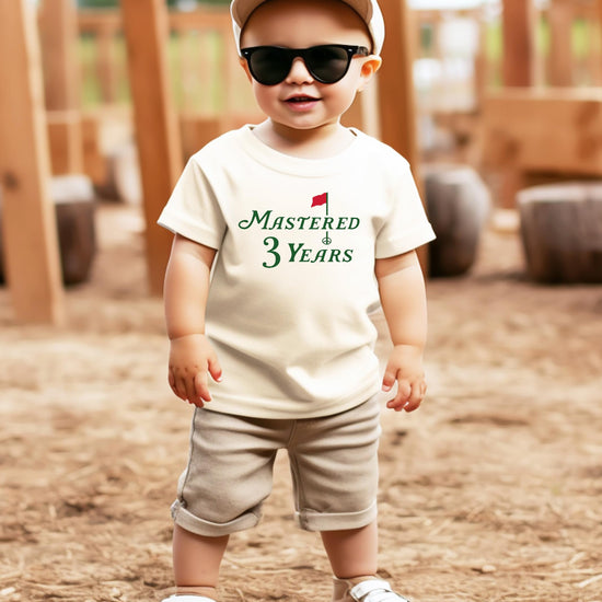 Toddler wearing a natural golf-themed third birthday shirt with Mastered 3 Years design