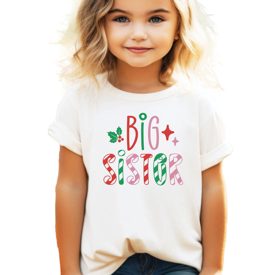 Girls big sister candy cane stripe Christmas graphic tee in natural color with holly and stars design