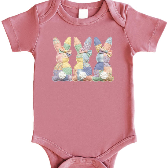 Close-up of ink-printed patchwork bunny design on a natural infant one piece bodysuit