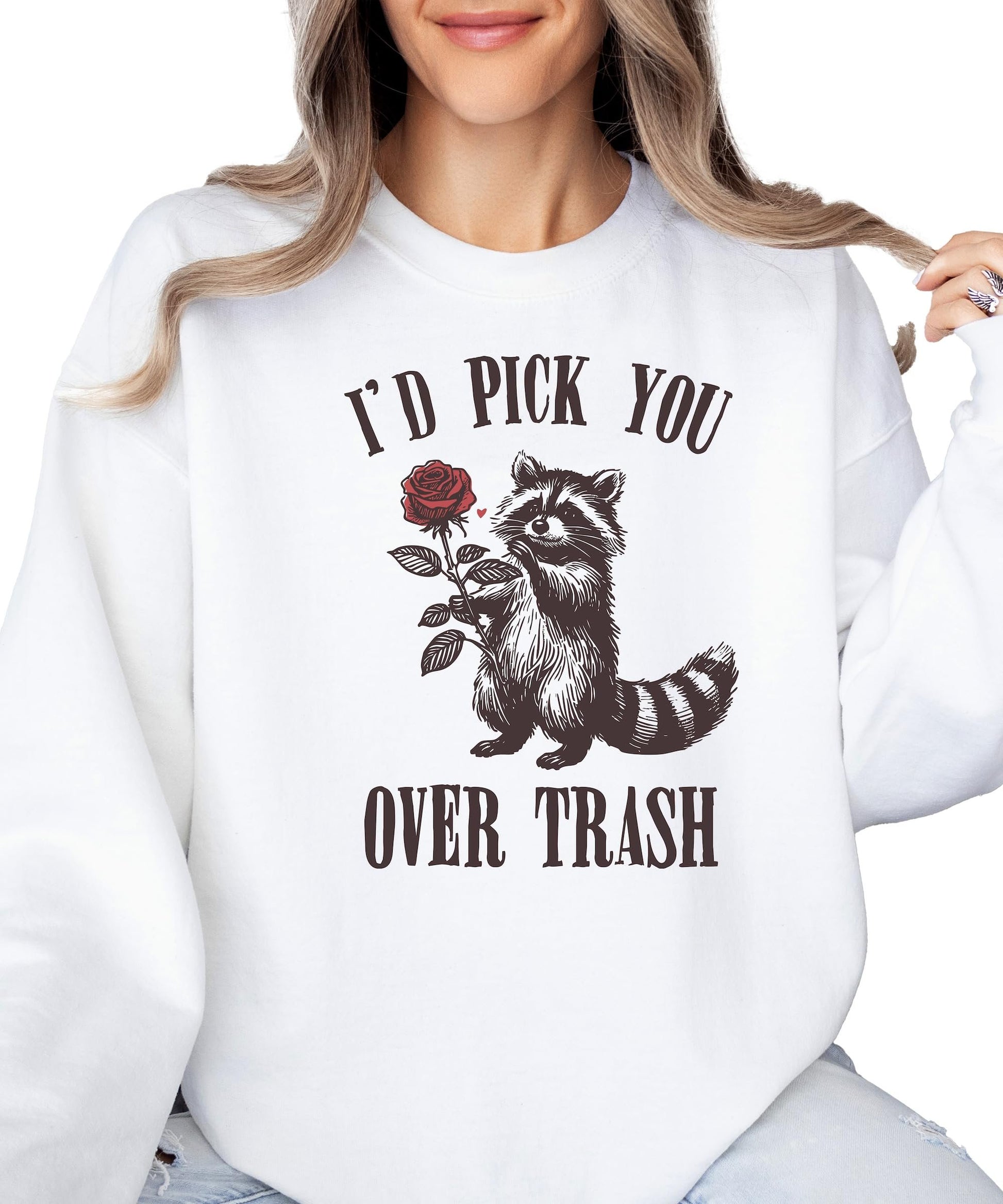 Women's white Valentine's Day sweatshirt with humorous raccoon and rose design laid flat