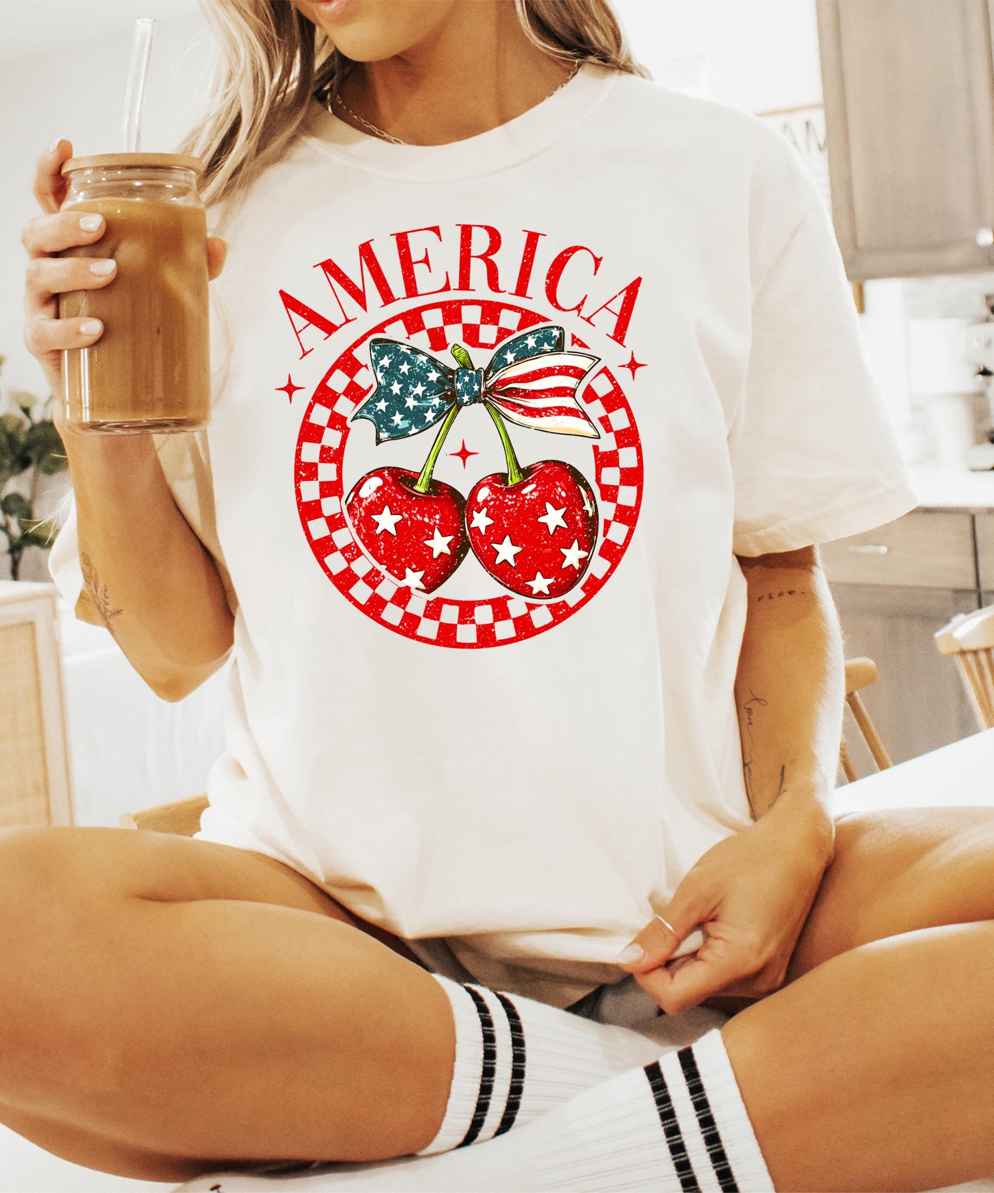 Flat lay of ivory patriotic tee featuring cherry with bow and stars design