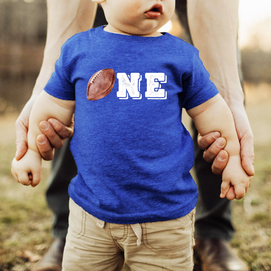 Boys first birthday sports themed shirt laid flat showing full graphic design
