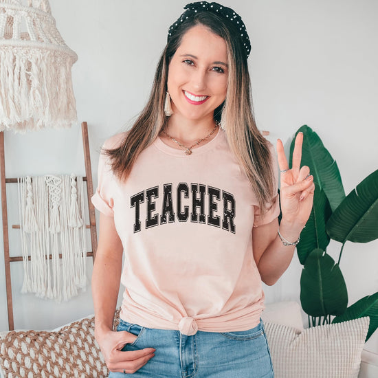 Collection of teacher varsity t-shirts in multiple colors - black, navy, and gray
