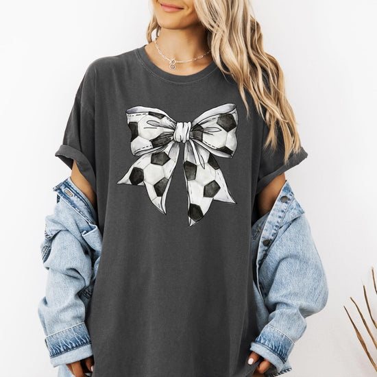 Flat lay of seafoam coquette bow soccer tee showing full graphic design