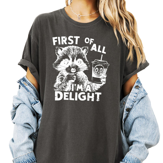Close-up of raccoon holding a drink graphic print on ivory adult tee