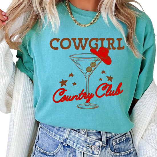 Close-up of vintage cowboy cocktail graphic print on women's country concert shirt