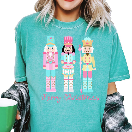 Side view of women's pastel nutcracker festive graphic tee in seafoam color