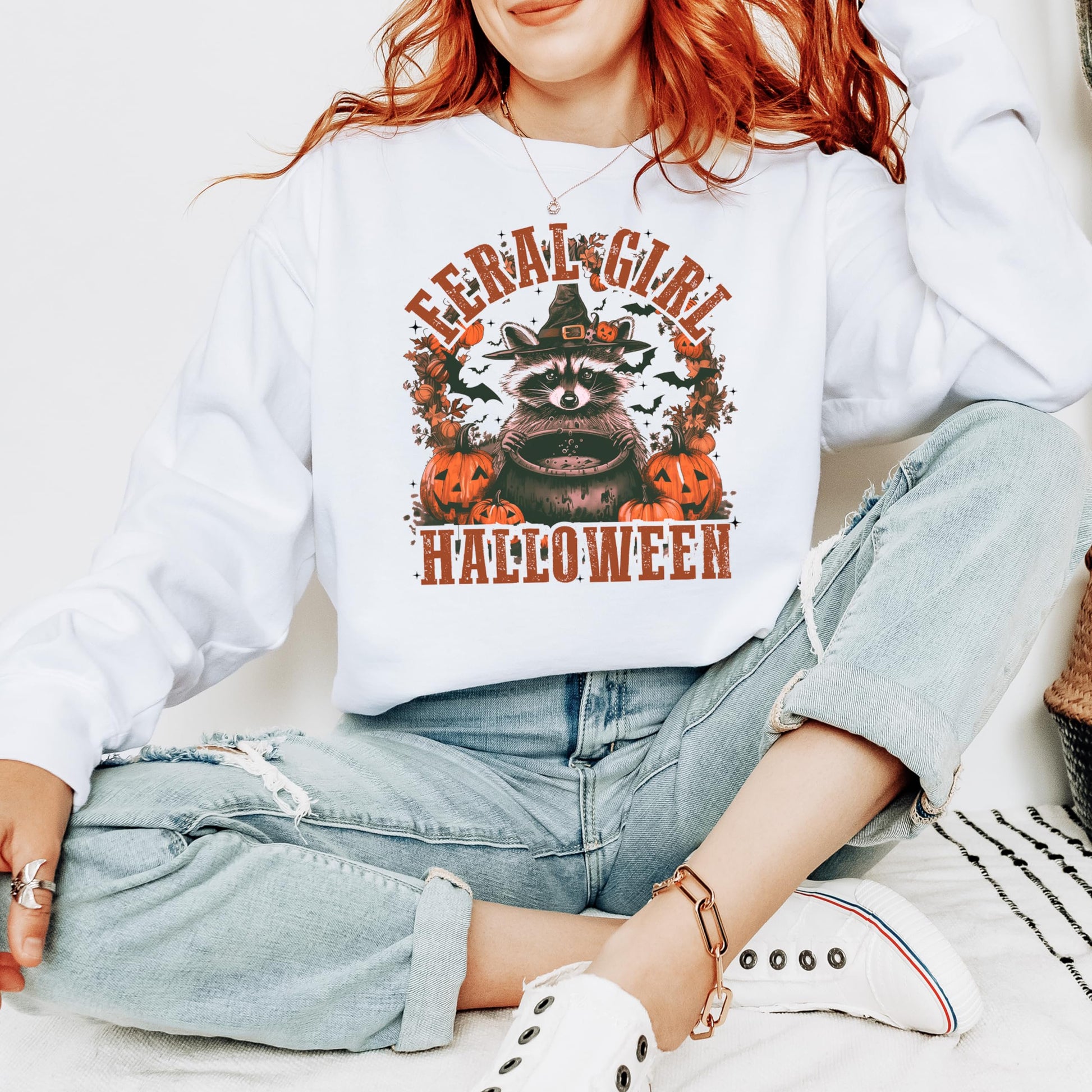Side or lifestyle view of women modeling the witchy raccoon Halloween pullover sweatshirt