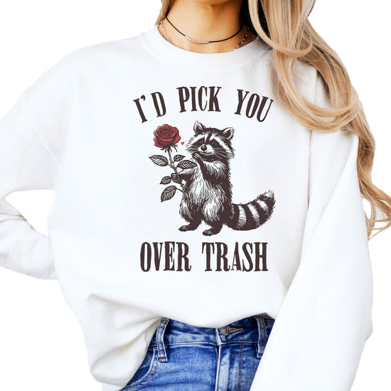 White sweatshirt with funny raccoon holding a rose graphic and text 'I'd Pick You Over Trash' for Valentine's Day