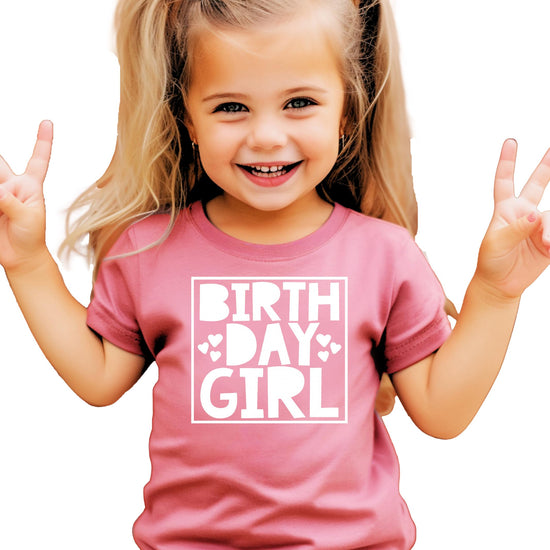 Close-up of birthday girl square with hearts print design in white on mauve