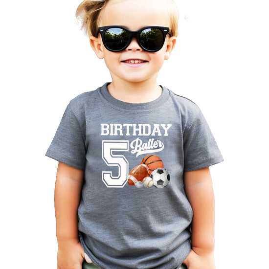 Kids black graphic tee laid flat showing 5th Birthday Baller sports design