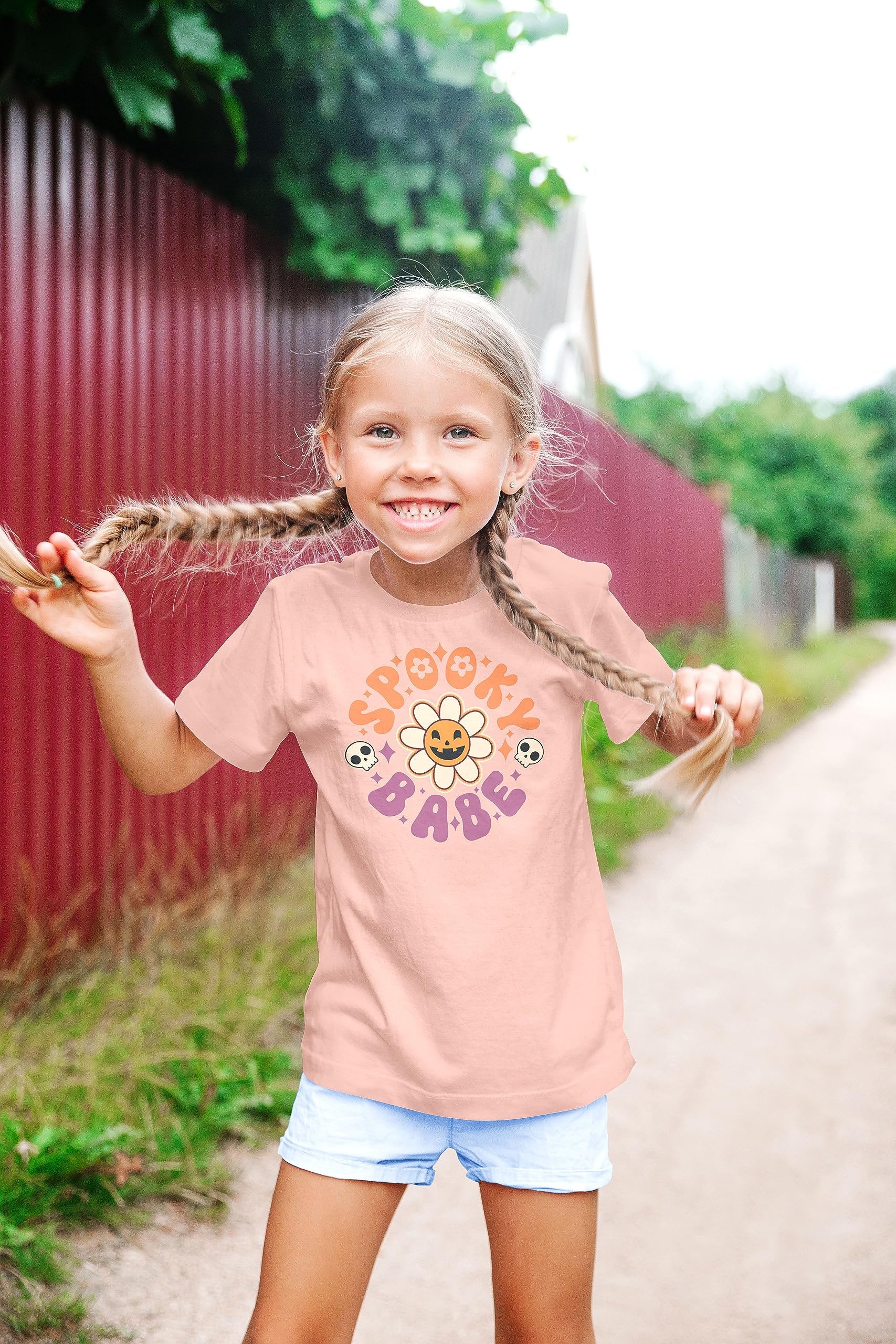 Spooky Babe Daisy Pumpkin Halloween shirt detail shot on peach youth girls tee
