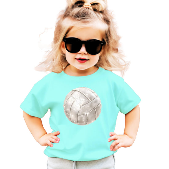 Close-up of faux glitter volleyball design on youth natural tee