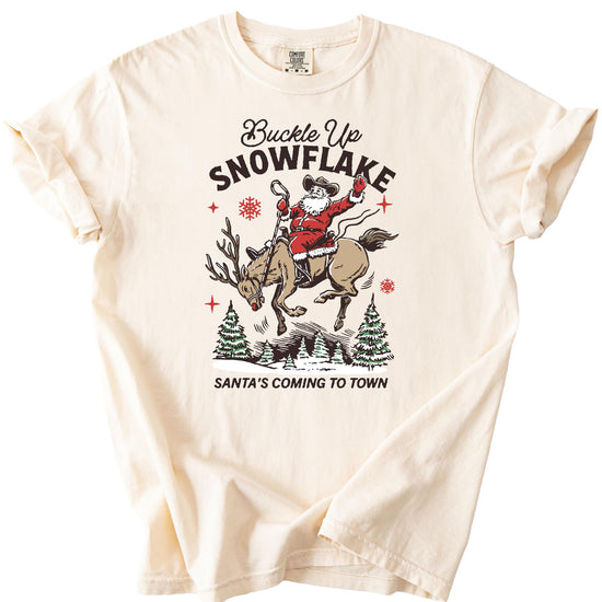 Model wearing Buckle Up Snowflake Santa western Christmas tee in ivory — casual holiday style