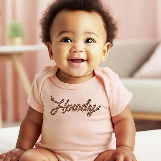 Side view of peach western Howdy baby bodysuit, soft fabric with snap closure for newborns