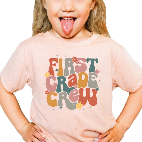 Young girl wearing First Grade Crew back to school graphic tee, full outfit view
