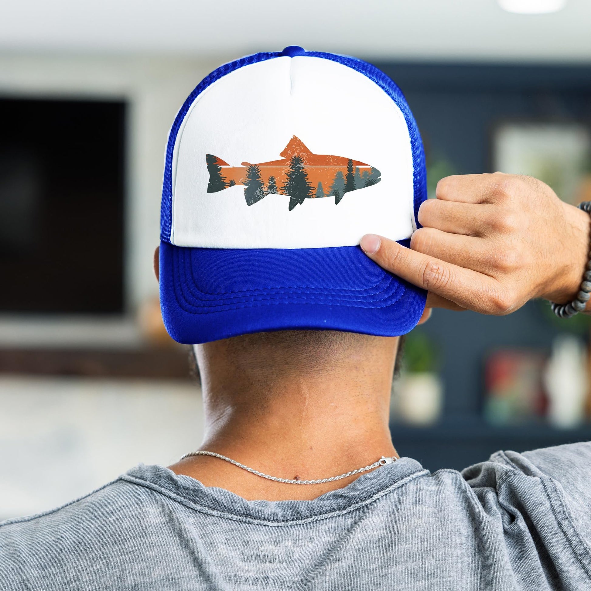Man wearing trout fishing sunset trucker hat - royal blue snapback back view