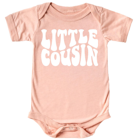 Close-up of Little Cousin retro text design on baby bodysuit