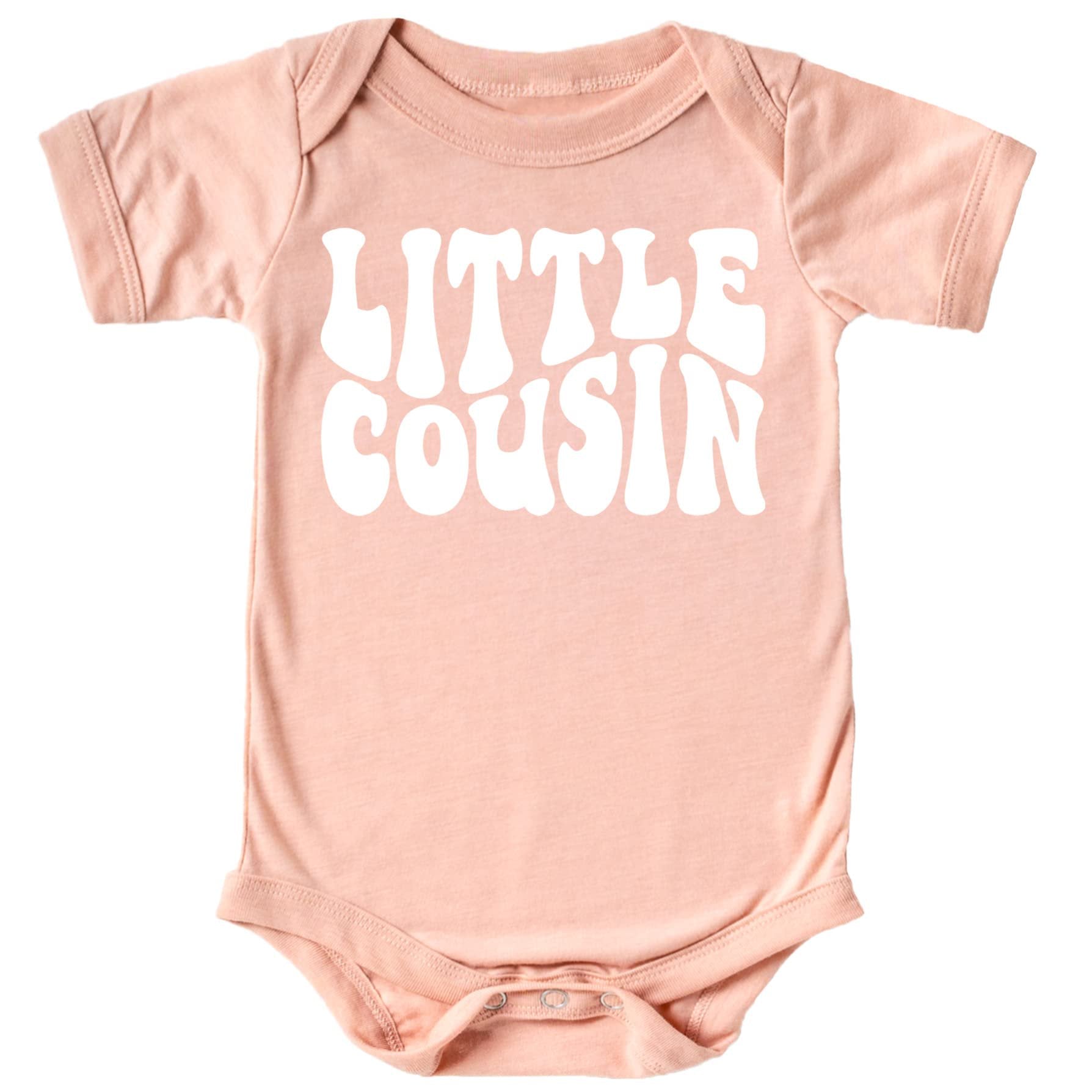 Close-up of Little Cousin retro text design on baby bodysuit