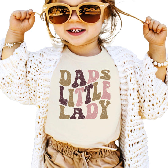 Toddler wearing Dad's Little Lady natural shirt with retro distressed daddy's girl graphic