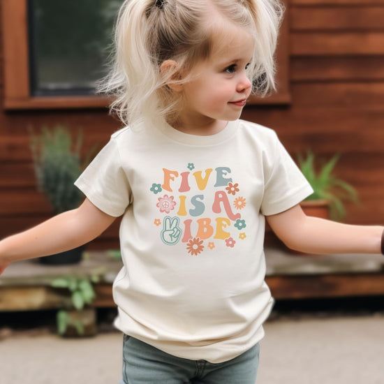 Close-up of Five is a Vibe retro-style birthday shirt print with floral and peace sign details for girls