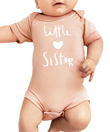 White Little Sister heart graphic bodysuit on mauve background for baby girls by Olive Loves Apple