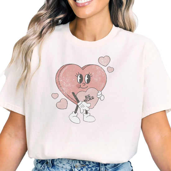 Detail shot of vibrant Be Mine heart graphic on pink kids Valentine's shirt