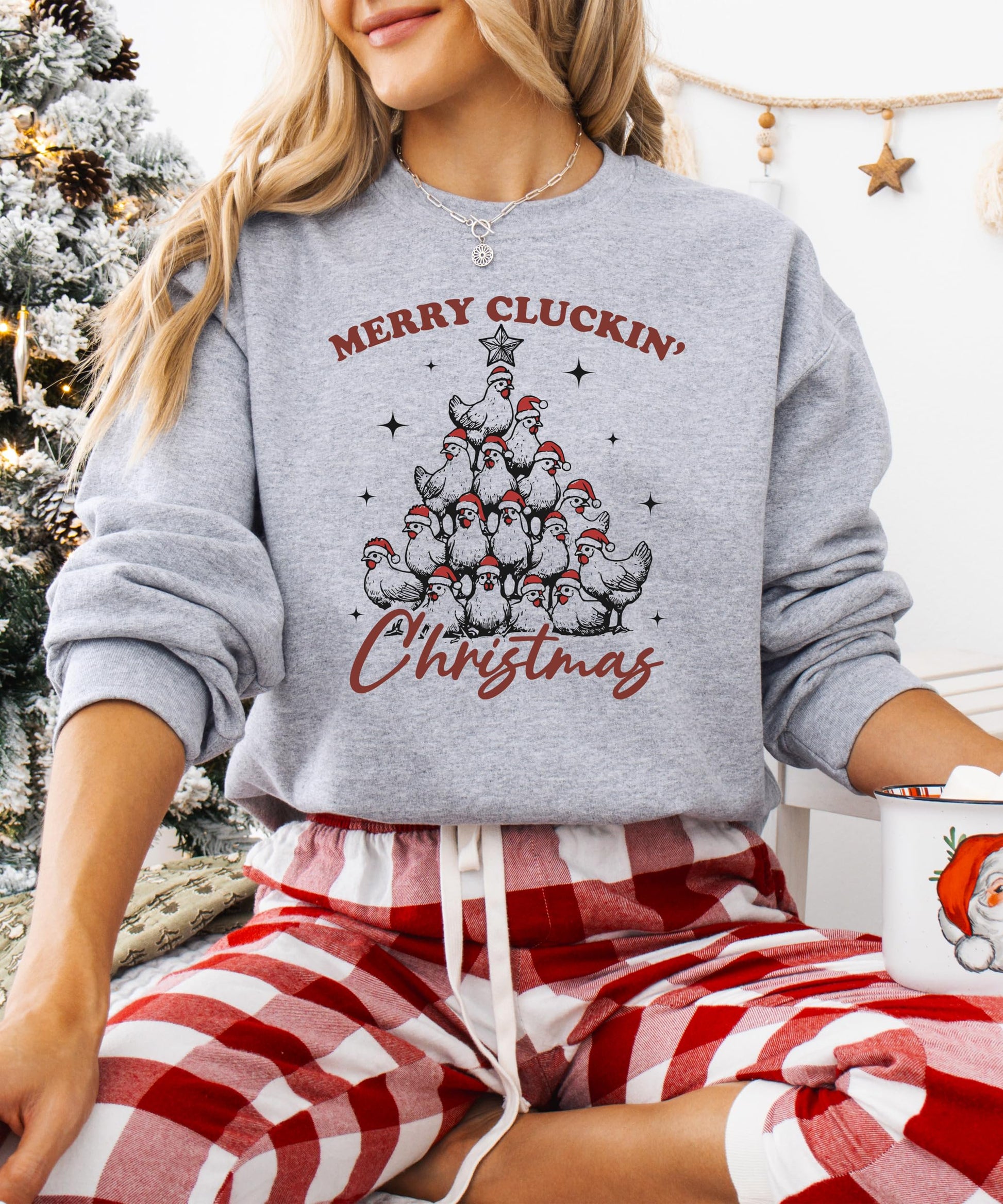 Detail shot of humorous chicken Christmas tree print on cozy white holiday pullover sweatshirt