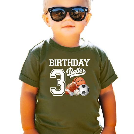 Flat lay of black toddler birthday shirt with bold sports-themed number 3 design