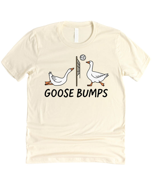 Front view of Goose Bumps Volleyball funny pun graphic shirt in peach on a flat lay background