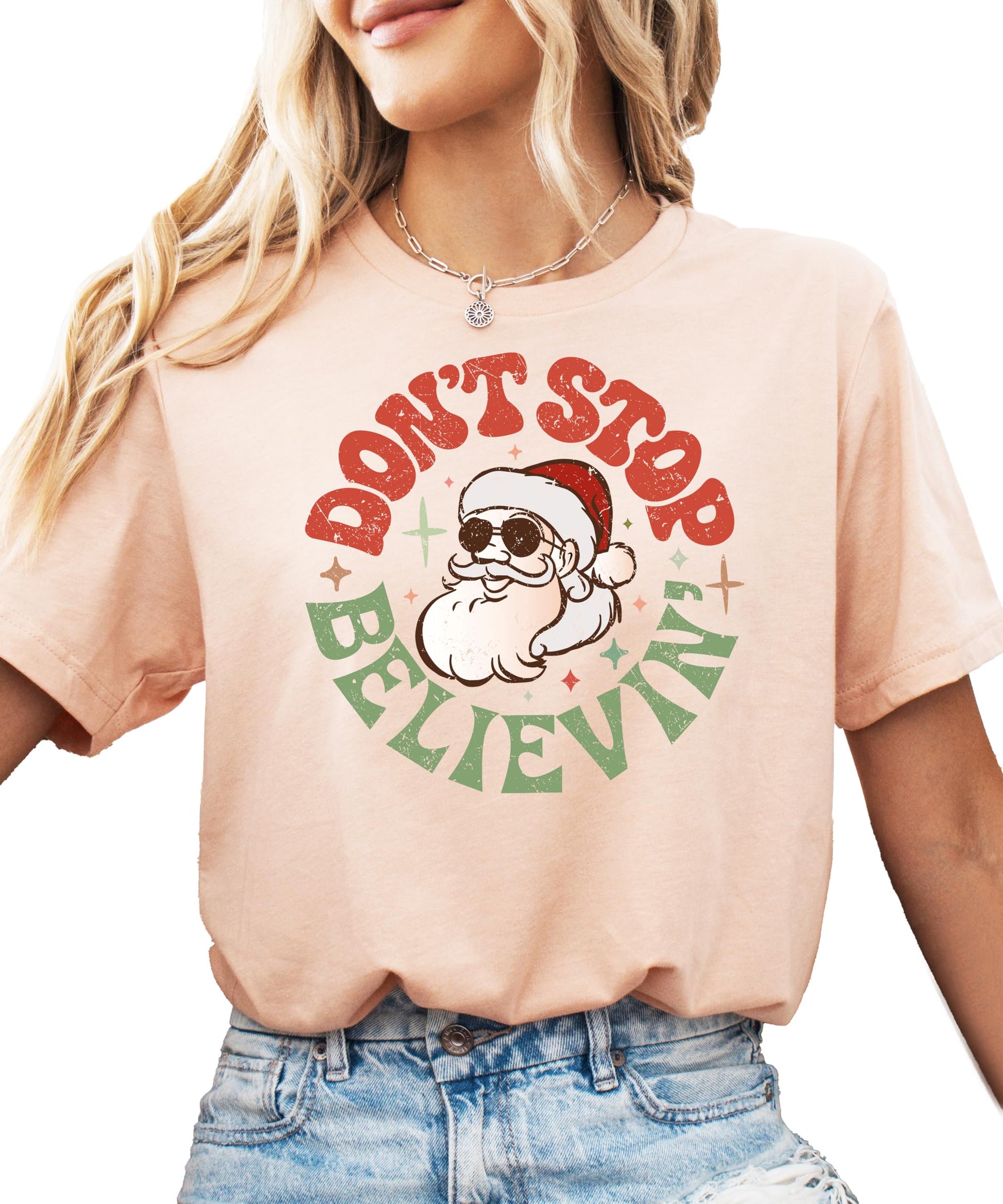 Women's natural color Christmas tee with Don't Stop Believing Santa graphic print
