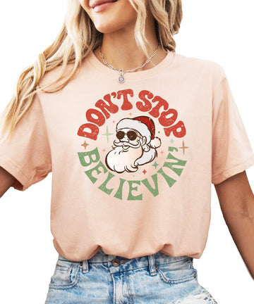 Women's natural color Christmas tee with Don't Stop Believing Santa graphic print